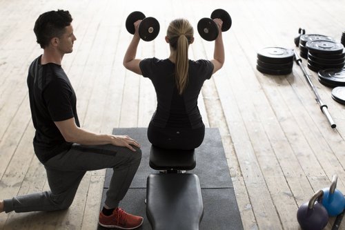 woman and coach working with dumbbells