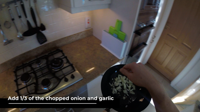man adding the chopped onion and garlic